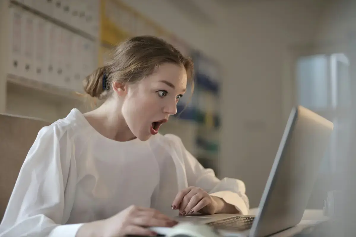 Student surprised while looking at laptop after discovering StraighterLine cheating tips